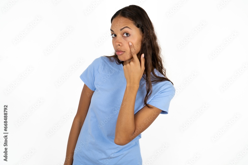 Young beautiful woman Pointing to the eye watching you gesture, suspicious expression. Young beautiful woman Pointing to the eye watching you gesture, suspicious expression.