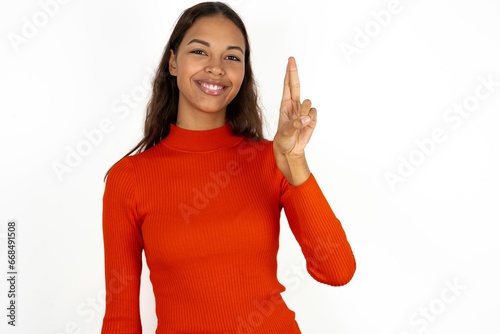 Young beautiful woman pointing up with fingers number ten in Chinese sign language Shi photo