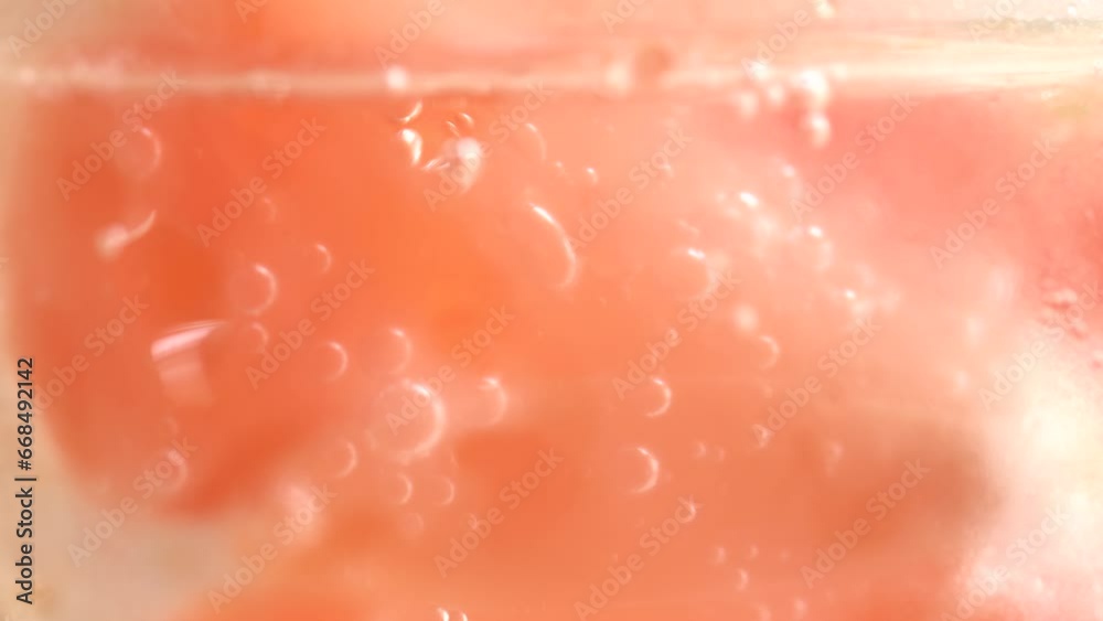 Fizzing water with grapefruit slices and ice cubes in glass, macro. Healthy lifestyle concept