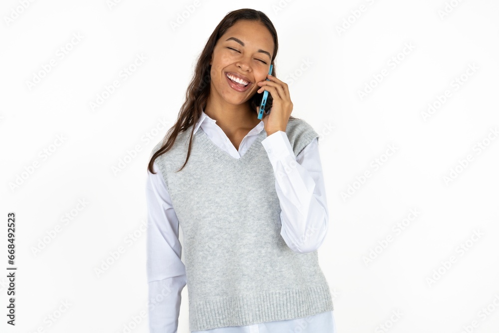 Funny Young beautiful woman laughs happily, has phone conversation, being amused by friend, closes eyes. Funny Young beautiful woman laughs happily, has phone conversation, being amused by friend, closes eyes.