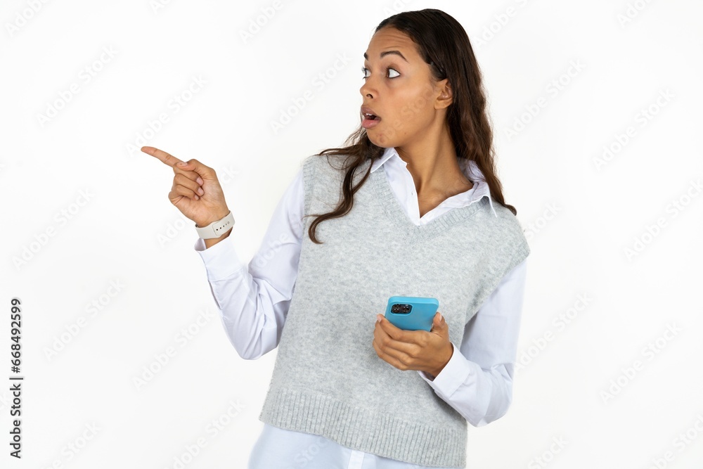 Stunned Young beautiful woman points sideways right copy space, recommends product, sees astonishing thing Stunned Young beautiful woman points sideways right copy space, recommends product, sees astonishing thing
