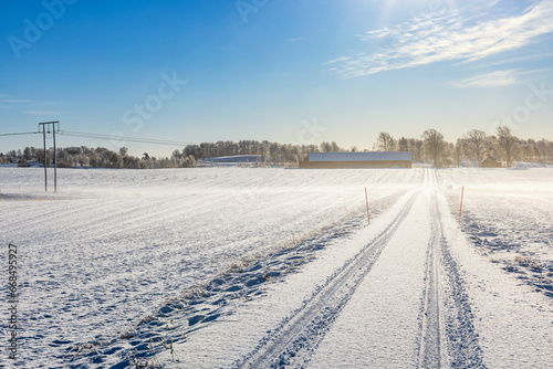 Winter road with car tracks in the snow on a cold winter day © Lars Johansson