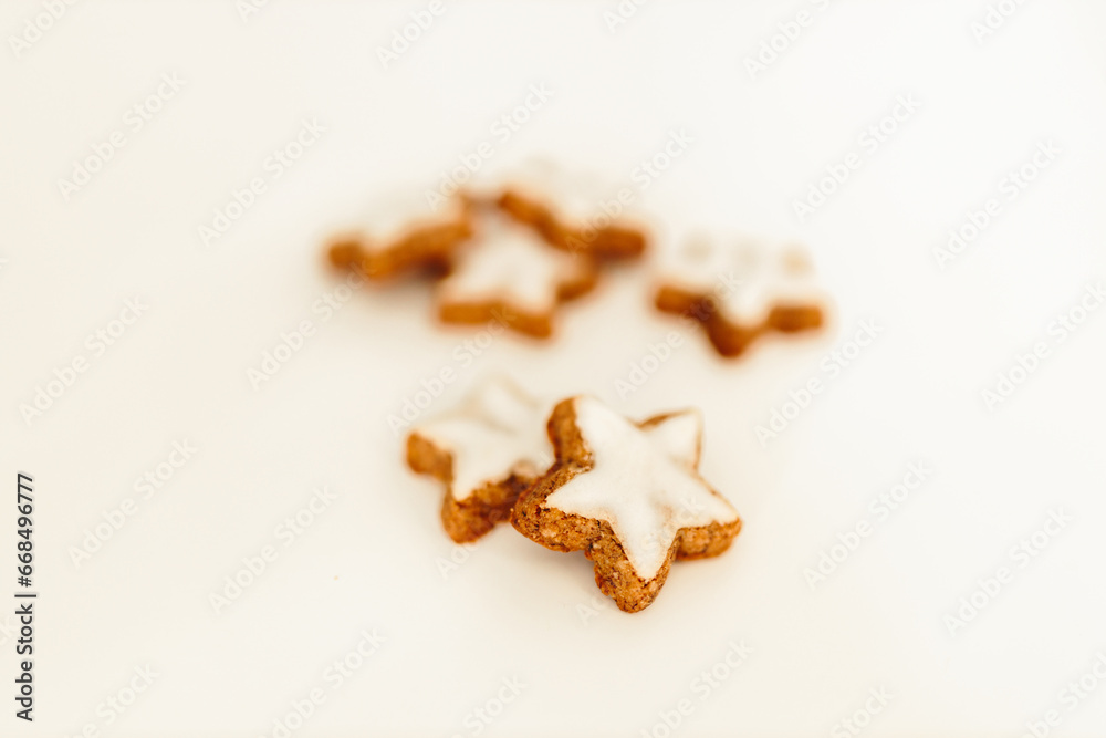 Gingerbread cookies in the shape of stars on a white table against a background of bokeh of New Year's golden lights. Christmas background. Winter card. Delicious pastries close-up Gingerbread cookies in the shape of stars on a white table against a background of bokeh of New Year's golden lights. Christmas background. Winter card. Delicious pastries close-up