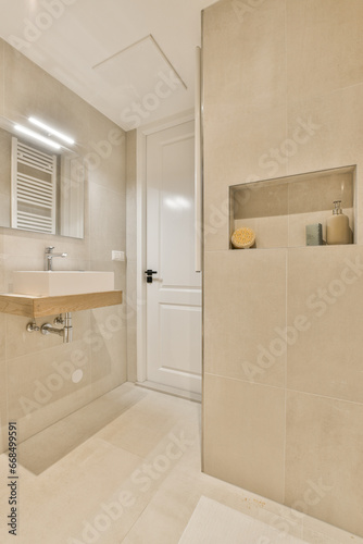 a bathroom with a sink, mirror and toilet paper on the wall next to it is a white bathtub