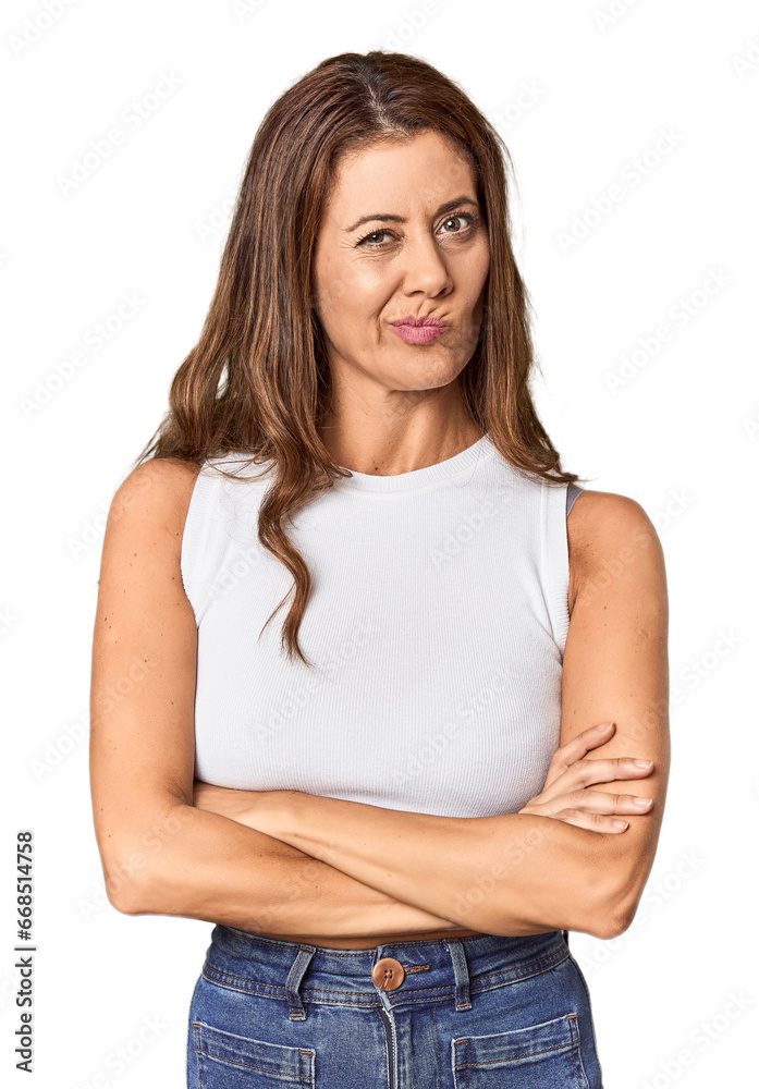 Obraz premium Middle-aged woman portrait in studio setting frowning face in displeasure, keeps arms folded.