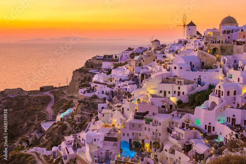 Sunset with white churches an blue domes by the ocean of Oia Santorini Greece photo