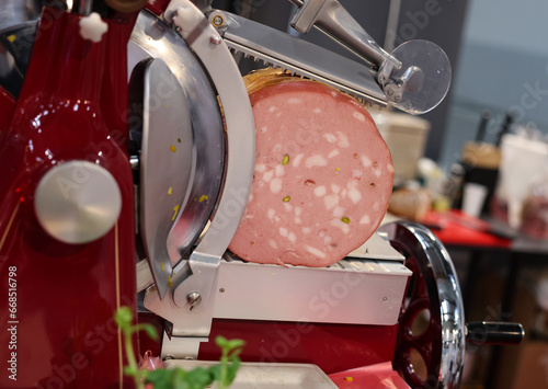 Mortadella ready to be cut on a professional slicer photo
