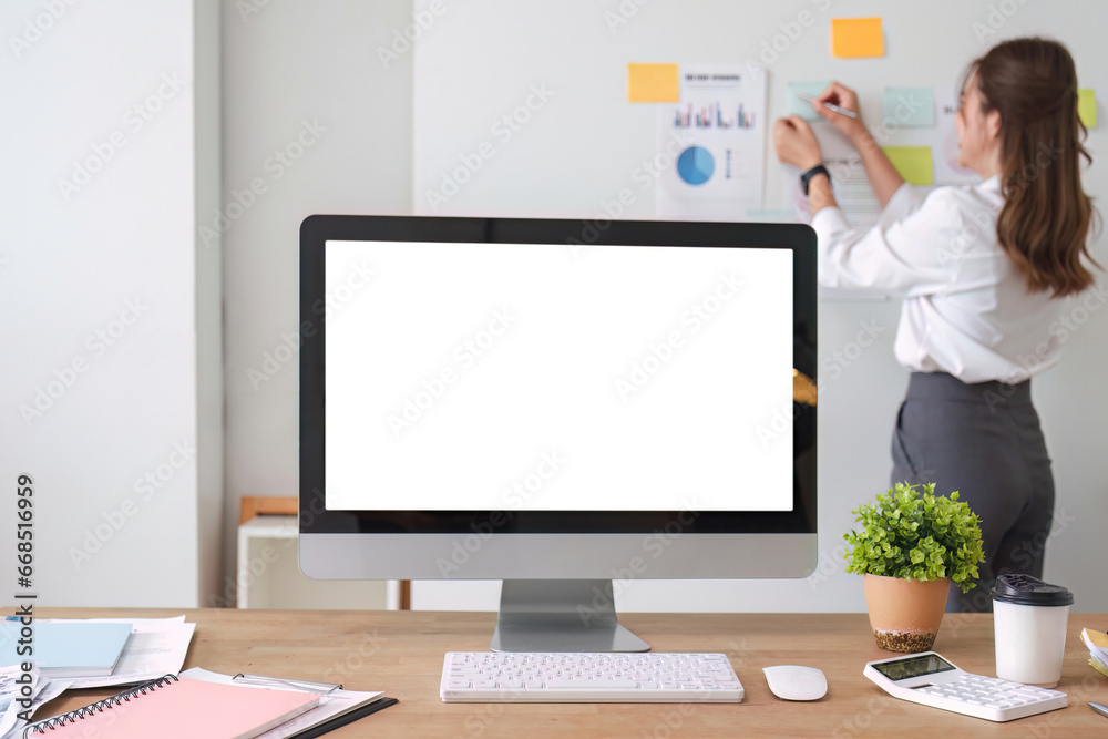 Modern work desk with computer open screen on white In the background, business people are planning their work on the board, financial and marketing reports, calculators and supplies. Modern work desk with computer open screen on white In the background, business people are planning their work on the board, financial and marketing reports, calculators and supplies.