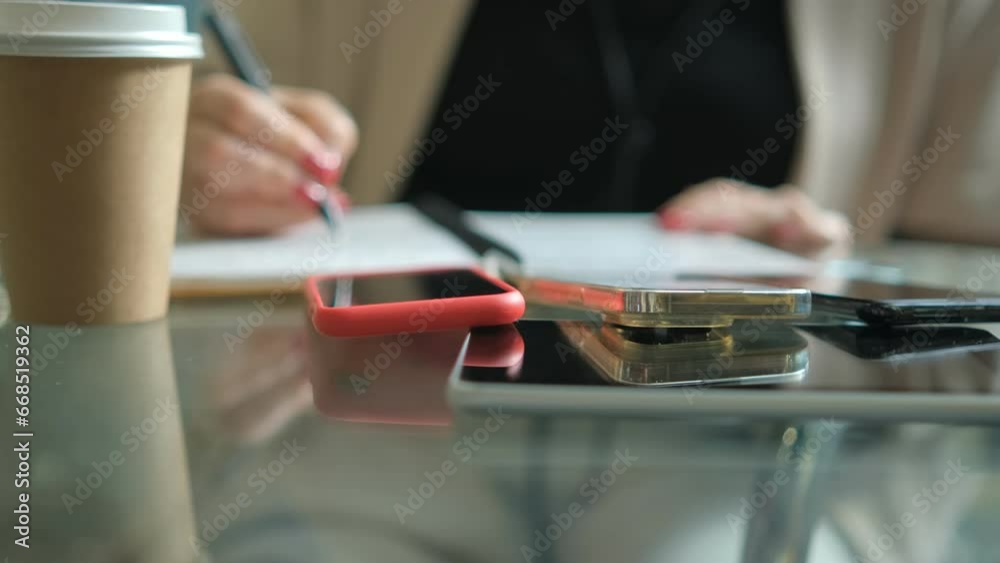 Stylish Young business woman sitting at table and writing in notebook. On table is smartphone, and tablet. Freelancer working, writing down new ideas 4K Stylish Young business woman sitting at table and writing in notebook. On table is smartphone, and tablet. Freelancer working, writing down new ideas 4K