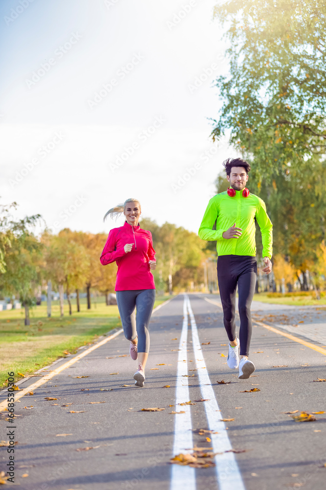 One Caucasian Positive Running Couple During Happily Jogging Outside as Runners Training Outdoors Working Out in City As Fitness Couple.