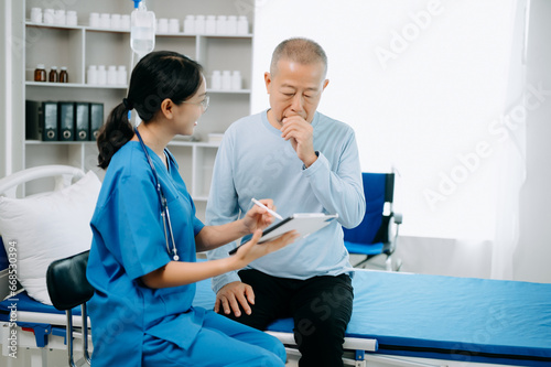 Asian Senior man being examined by a doctor in background.