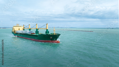 Wind Turbine on Ship, Transportation of blades for wind turbines on a cargo ship. Heavy load carrier on cargo ship loaded with Electric Wind Turbine Blades.