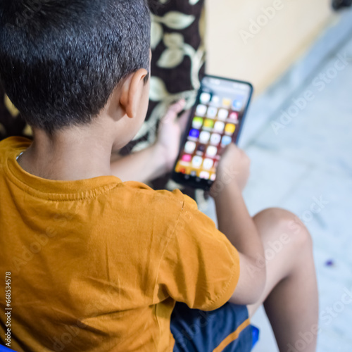 Portrait of Asian smart happy little boy using Mobile phone at home. Little boy holding mobile smart phone, online back to school concept. Online Class concept