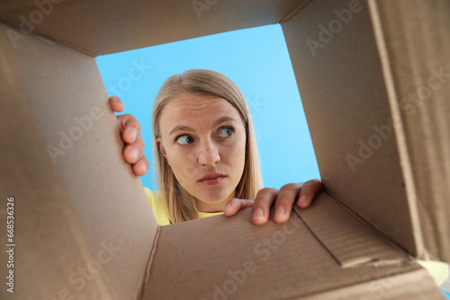 An attractive blonde looks into a cardboard box