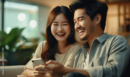 Couple asian people using smartphone and laughing. Happiness moment photo
