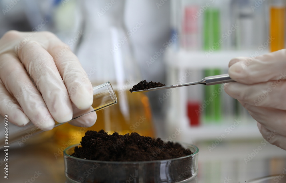 Female chemist in white protective gloves hold test tube against chemistry lab background closeup. Express research crop soil content of beneficial and harmful substances concept
