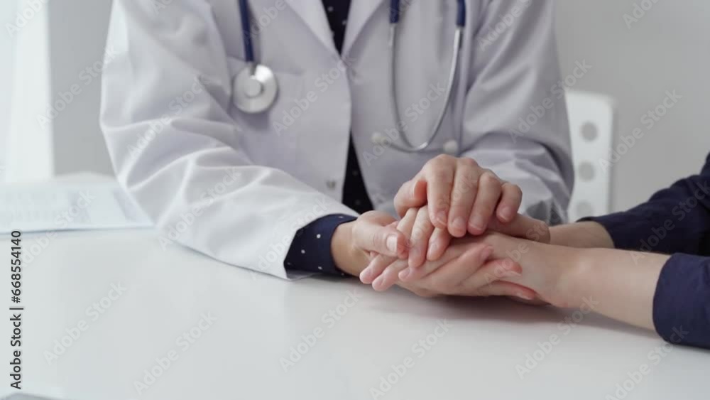 Doctor and patient sitting at the table and discussing something. The pediatrician in a blue dotted blouse and white medical coat is reassuring the young woman. Medicine and empathy concepts Doctor and patient sitting at the table and discussing something. The pediatrician in a blue dotted blouse and white medical coat is reassuring the young woman. Medicine and empathy concepts