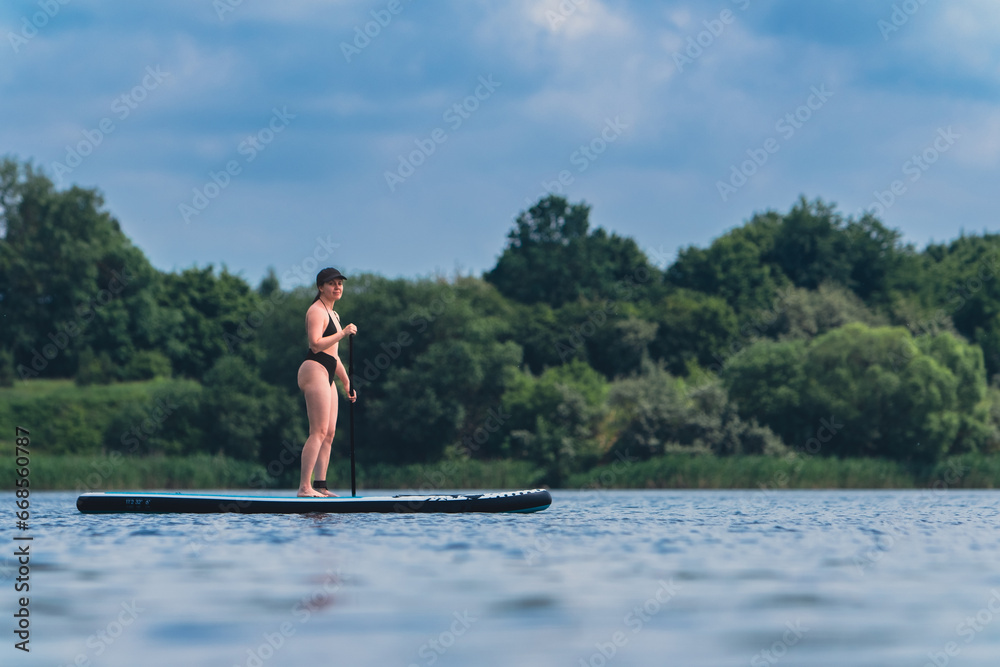 attractive woman in swimwear on supboard