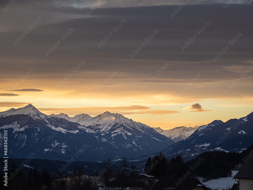 Colorful winter snow sunset over an austrian alps village with mountains