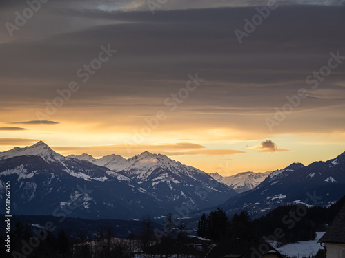 Colorful winter snow sunset over an austrian alps village with mountains