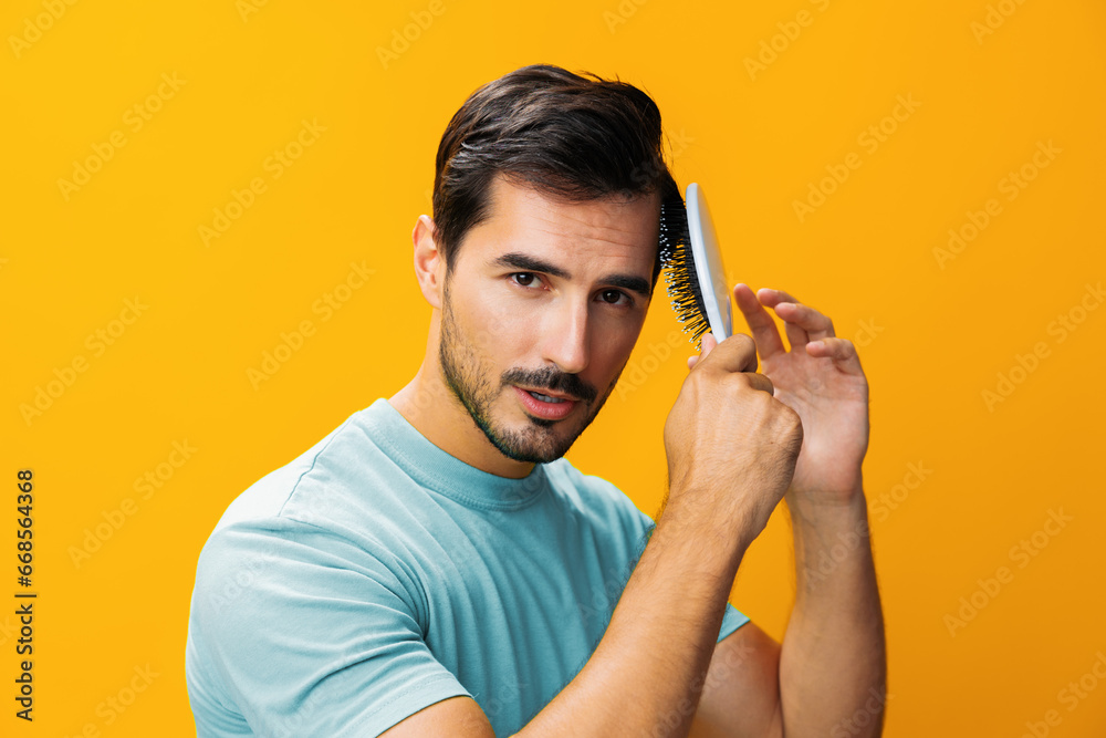 Man smiling studio hair brushing comb background face barber handsome hair loss hairstyle portrait close-up yellow