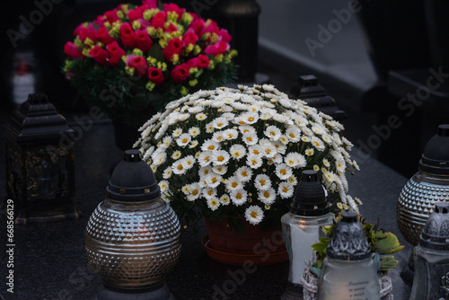 Warsaw, Poland - October 24, 2023: Graves in the cemetery on a cloudy, foggy day. Weather for All Saints' Day. Candles and flowers on graves.