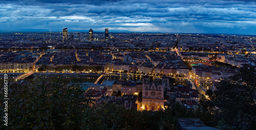 Panorama of Lyon skyline by night with city lights from Fourviere hill, just before sunrise, showing medieval St John cathedral and modern  district of 