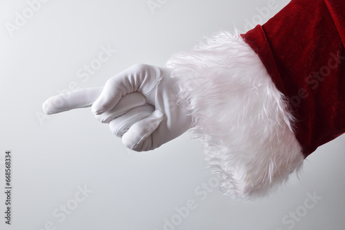 Santa claus hand with gloves pointing and white isolated background