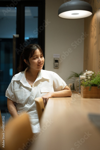 Portrait of attractive young woman sitting counter.