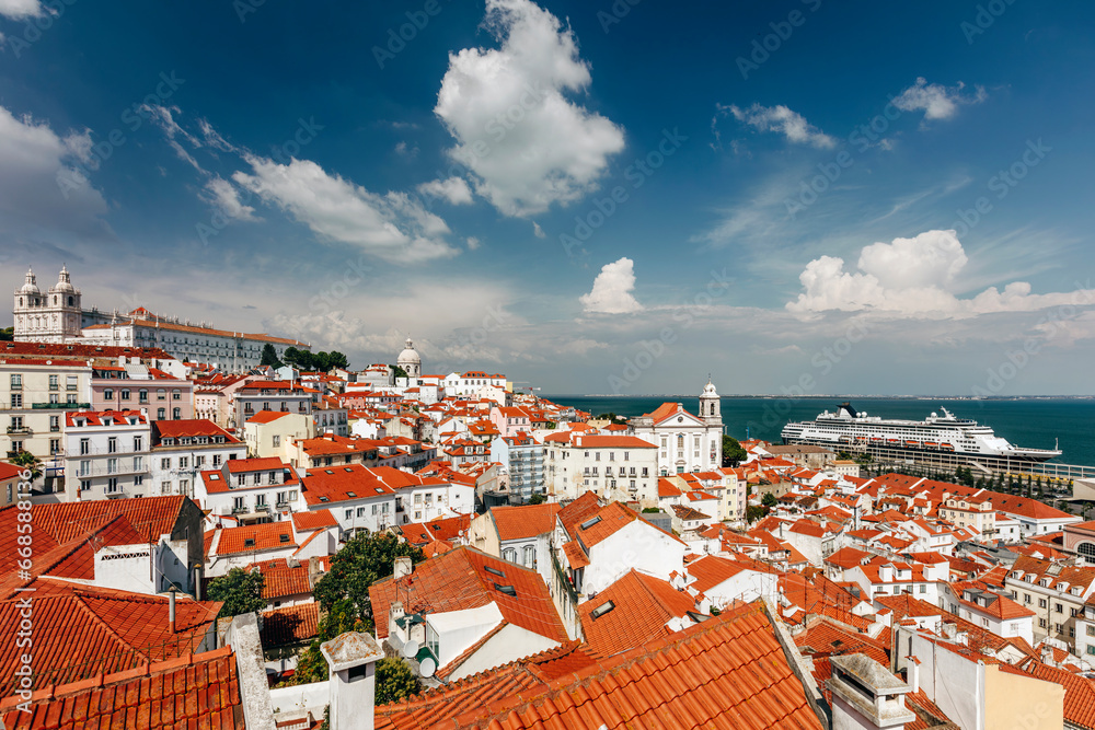 Naklejka premium View over Alfama, old part of Lisbon, with the towers of the Monastery of St. Vincent and the dome of the National Pantheon, as it seen from Portas do Sol viewpoint. 
