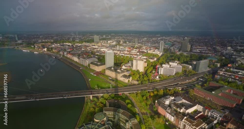 Dusseldorf: Aerial view of city in Germany, skyline with bridge over river Rhine. Timelapse of a full rainbow appearing photo