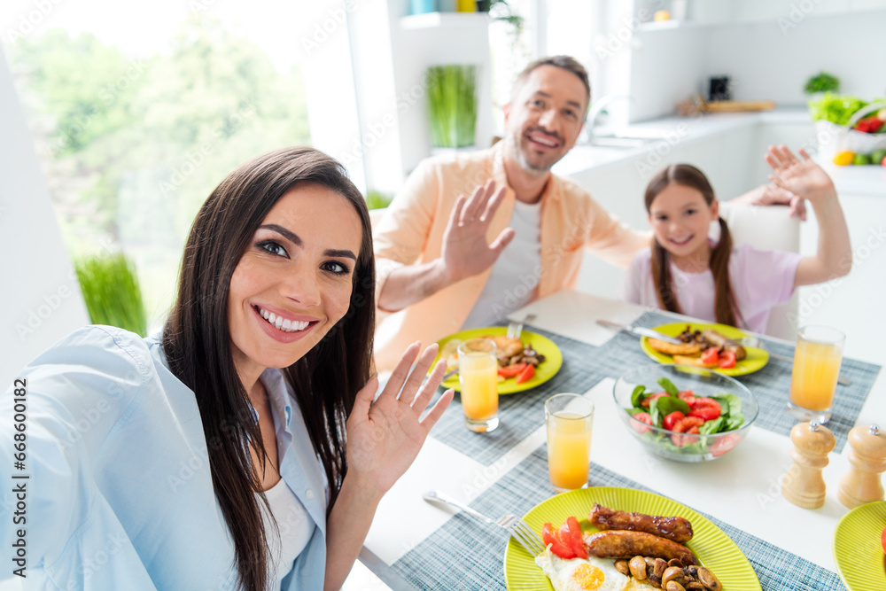 Photo of funny idyllic family hands waving hi make selfie recording video kitchen table homemade foot flat indoors