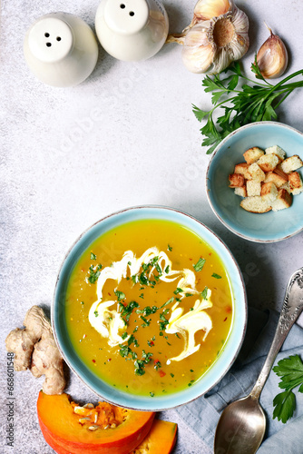 Autumn pumpkin soup with ginger and garlic. Top view with copy space.