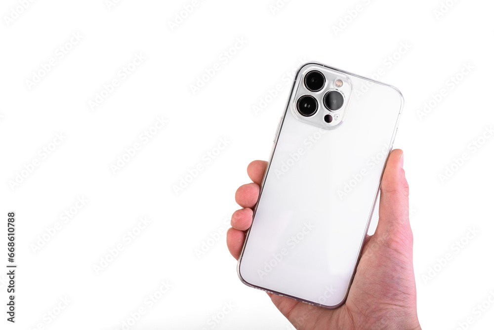 Hand holding white smartphone with silicone transparent phone case isolated on white background. Hand holding white smartphone with silicone transparent phone case isolated on white background.