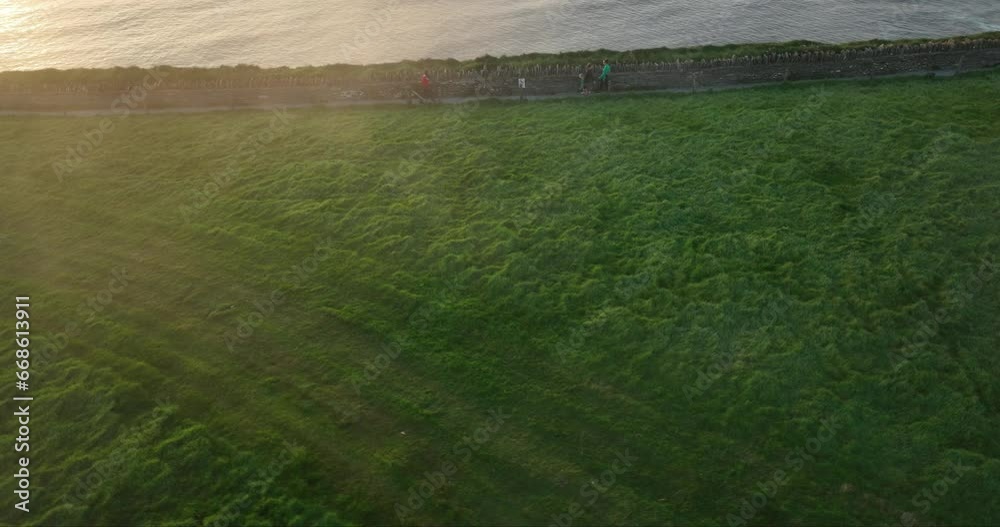 People walking on a misty trail along the Cliffs of Moher at sunset 4k People walking on a misty trail along the Cliffs of Moher at sunset 4k