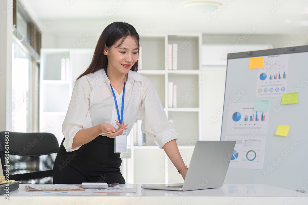 Businesswoman uses laptop to do financial management and calculations, mathematics on white table in office, business management, graphs, tax, accounting, statistics and analytical research concepts. Businesswoman uses laptop to do financial management and calculations, mathematics on white table in office, business management, graphs, tax, accounting, statistics and analytical research concepts.