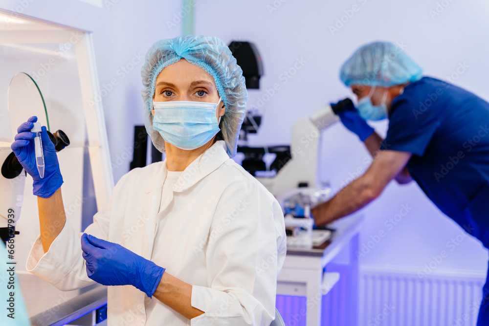 Scientist holding eppendorf tubes. Professional female is working on a vaccine in a scientific research laboratory. Genetic engineer workplace. Technology and science concept. Scientist holding eppendorf tubes. Professional female is working on a vaccine in a scientific research laboratory. Genetic engineer workplace. Technology and science concept.
