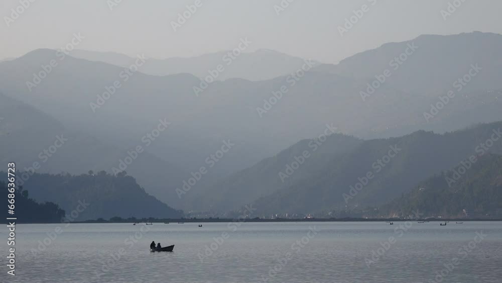 People use rowing boats to sail over Phewa Lake, a popular place to visit in Pokhara, travel and scenery Nepal People use rowing boats to sail over Phewa Lake, a popular place to visit in Pokhara, travel and scenery Nepal