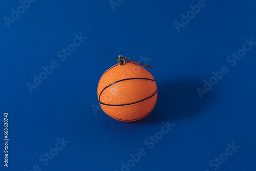 Minimal Christmas scene with orange basketball as Christmas tree bauble. Holiday and sport concept. © Aleksandar
