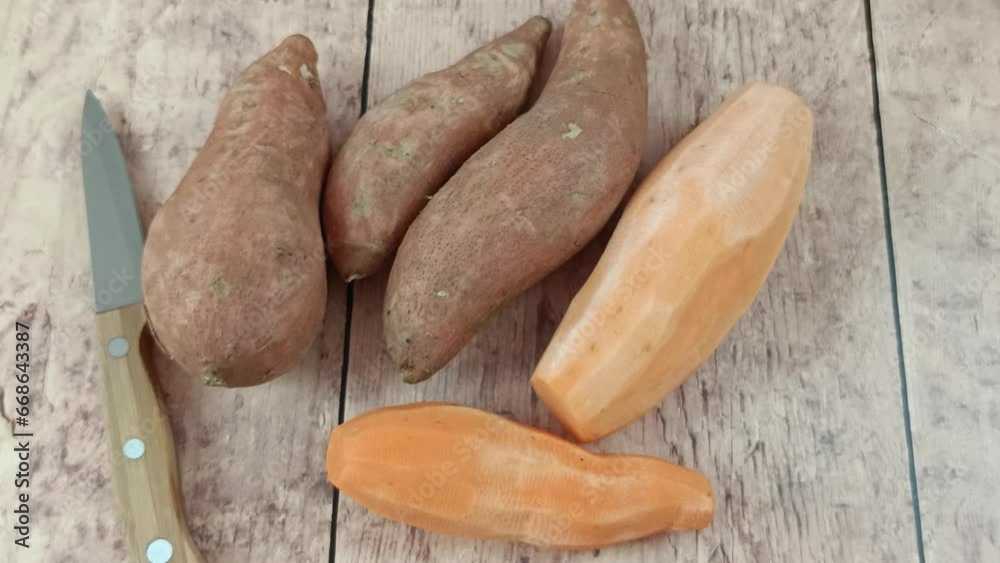 tas de patates douces épluchées et crues sur une planche à découper tas de patates douces épluchées et crues sur une planche à découper
