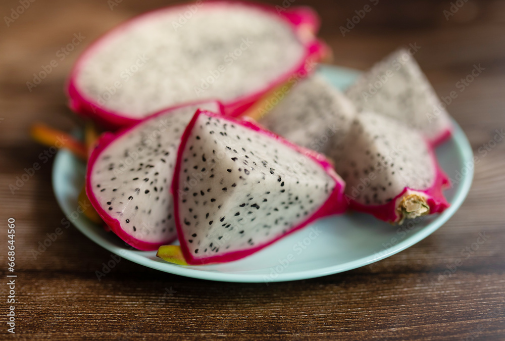Red dragon fruit or pitahaya on plate on wooden background, Tropical fruit in summer season. Red dragon fruit or pitahaya on plate on wooden background, Tropical fruit in summer season.