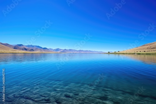 a clear, placid lake under a blue sky
