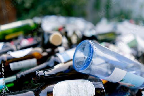 Close-up shot of glass bottles packed in a special garbage bag at waste recycling station for its disposal photo