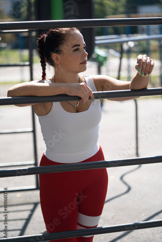 Girl doing sports on exercise equipment at the stadium
