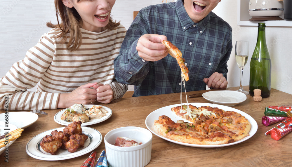 ピザを食べる若いカップル