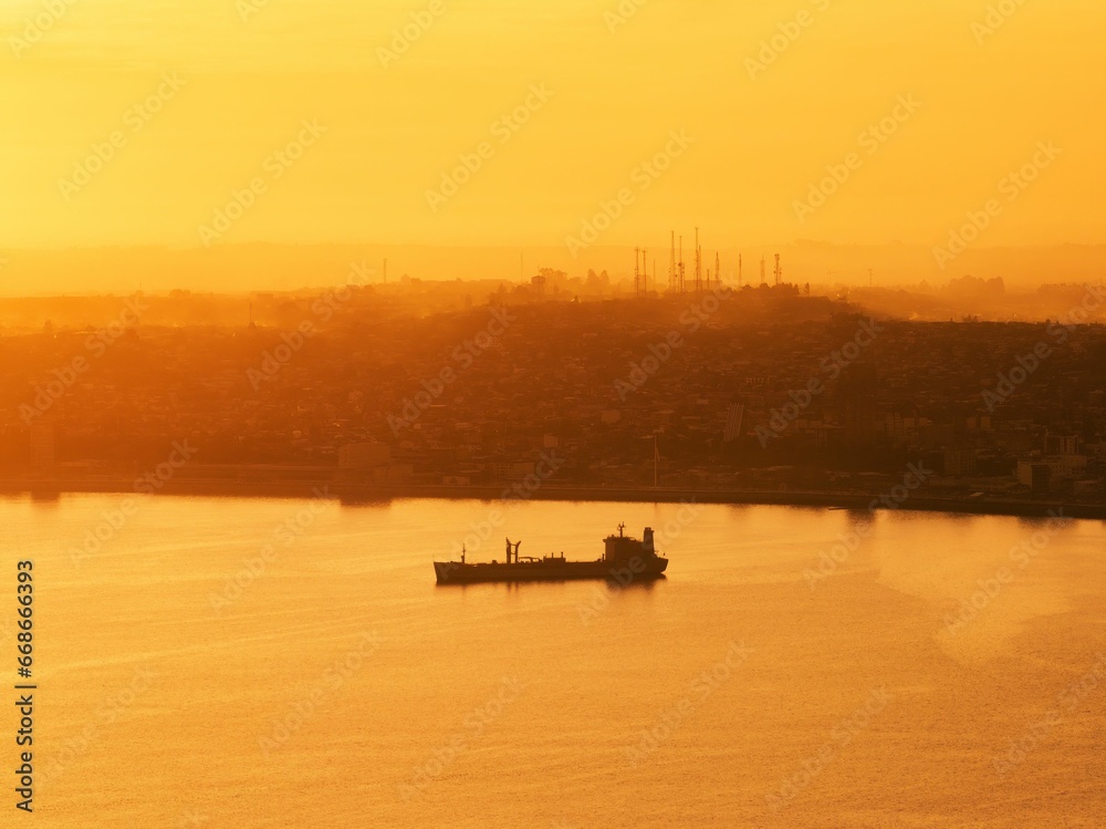 Aerial shot of the bay of the city of Puerto Montt with golden sunset light.
