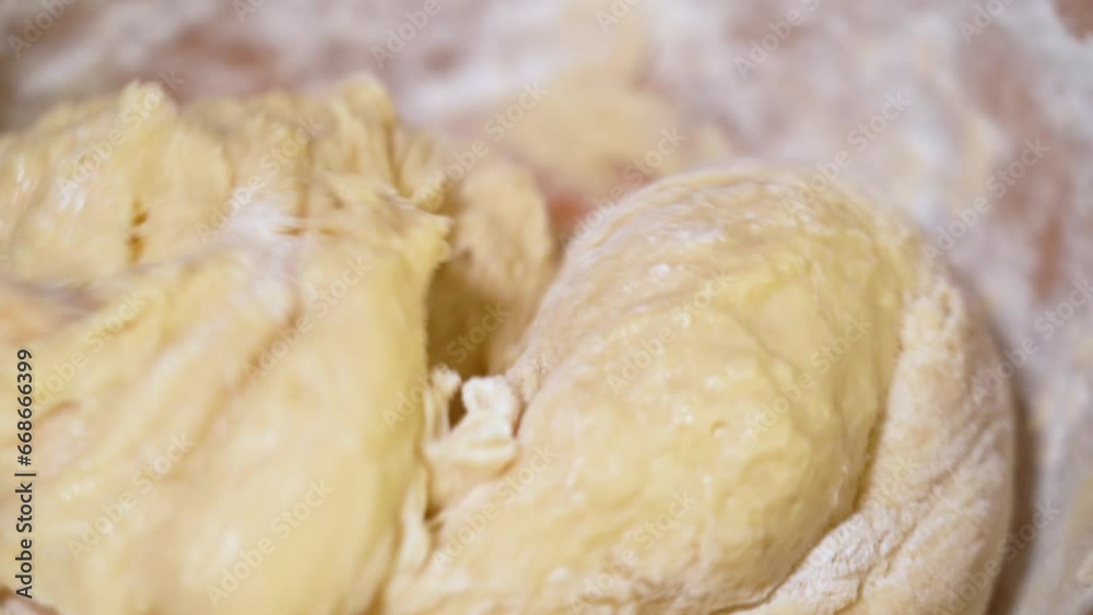 Baker kneading dough in flour on table.
Baker kneading dough in flour on table.