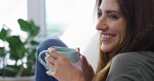 Thinking, happy and woman drinking coffee in home living room, peace or relax for health on sofa. Person smile with tea cup in lounge, dream or planning future in the morning, calm or vision in house photo