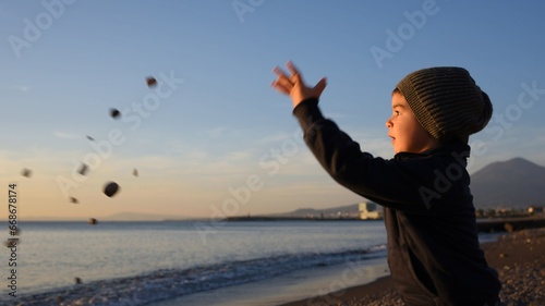 Bambino che lancia sassi (e le sue speranze) verso il cielo, verso l'orizzonte, verso il mare: verso il futuro!