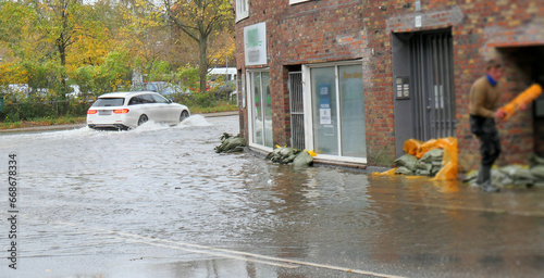 Flooded Danish city with water in the streets and people trying to protect the buildings from water damage with sandbags